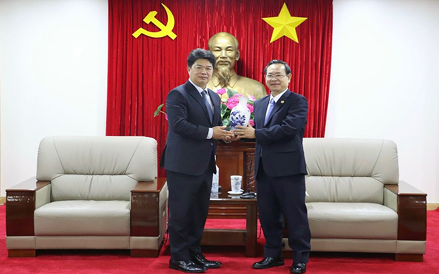 Ông Nguyễn Văn Dành (bên phải) trao quà lưu niệm cho ông Hàn Quốc Diệu