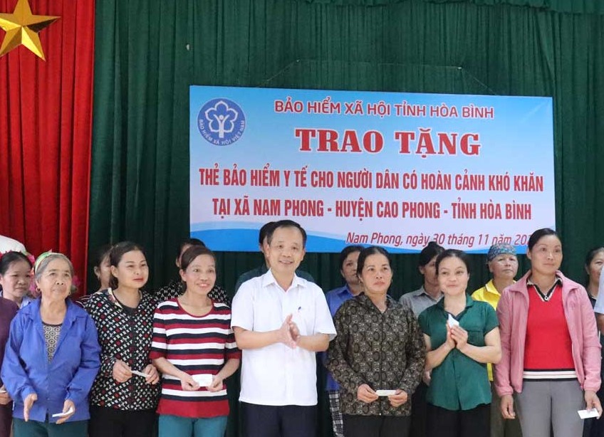 Đại diện lãnh đạo BHXH tỉnh Hòa Bình  trao tặng thẻ BHYT cho các hộ có hoàn cảnh khó khăn ở xã Nam Phong (Cao Phong).