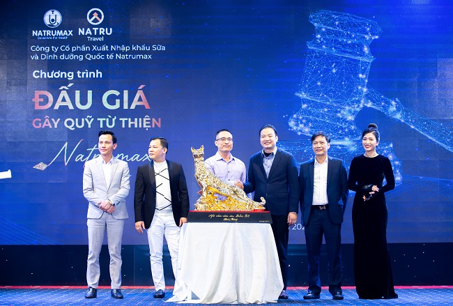 Ông Nguyễn Tất Tùng - CT HĐQT Natrumax (người đứng thứ 3 bên phải) trao vật phẩm đấu giá cho người đấu giá thành công.