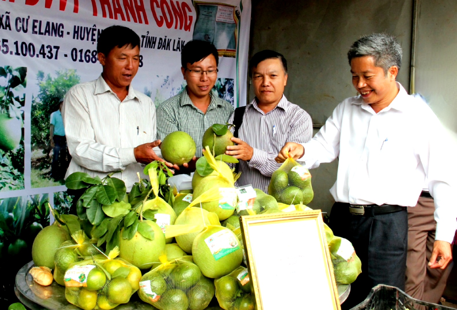 Chủ tịch UBND huyện Ea Kar Nguyễn Văn Hà (bìa phải) tham quan gian trưng bày sản phẩm cây ăn quả tại Hội thảo phát triển cây ăn quả huyện Ea Kar.