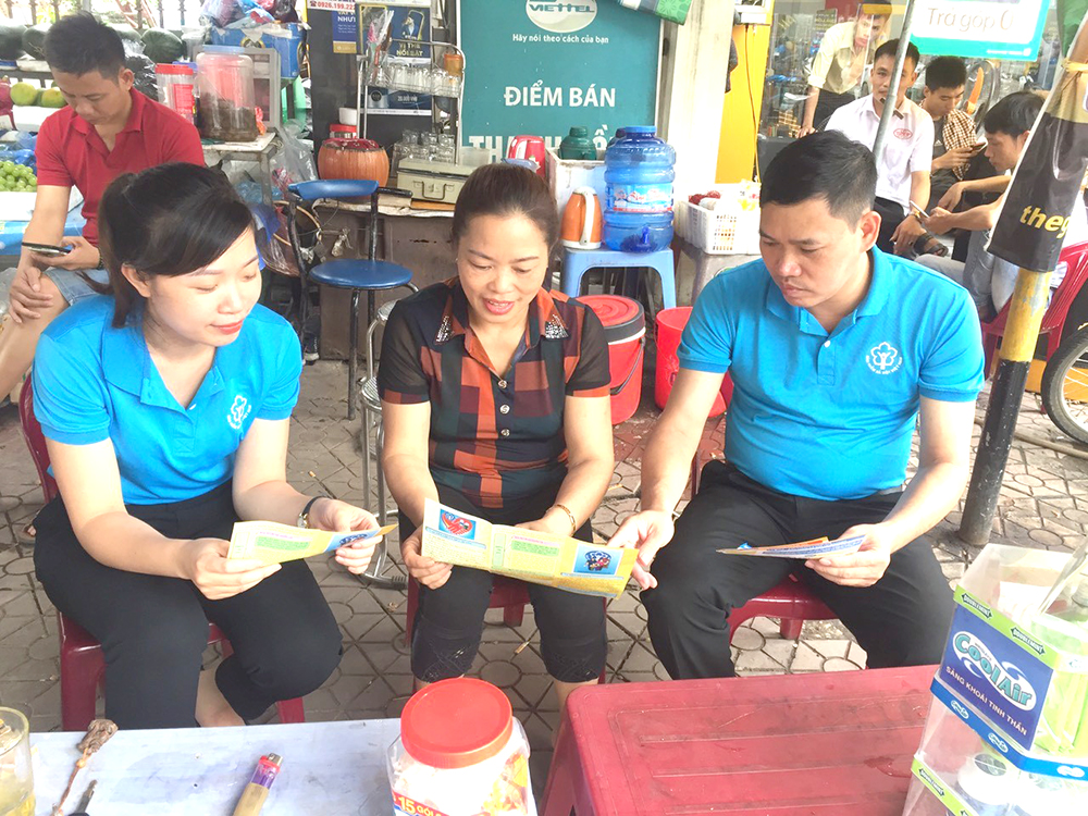 Nhân viên BHXH huyện Cẩm Khê tuyên truyền cho người dân về lợi ích khi tham gia BHXH tự nguyện