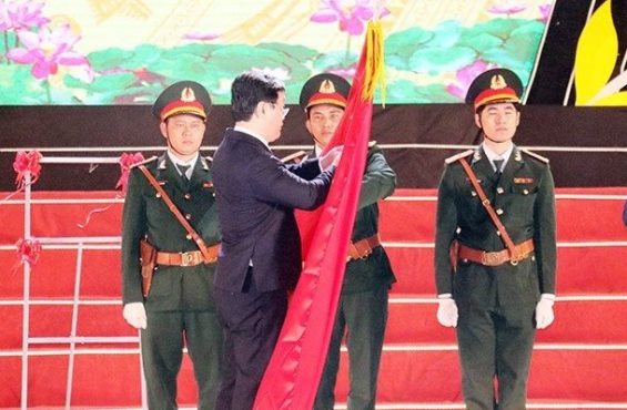 Chủ tịch UBND tỉnh Nghệ An Nguyễn Đức Trung thừa ủy quyền của Chủ tịch nước gắn Huân chương Lao động hạng Ba lên Lá cờ truyền thống cho Đảng bộ, Chính quyền và Nhân dân huyện Quỳnh Lưu