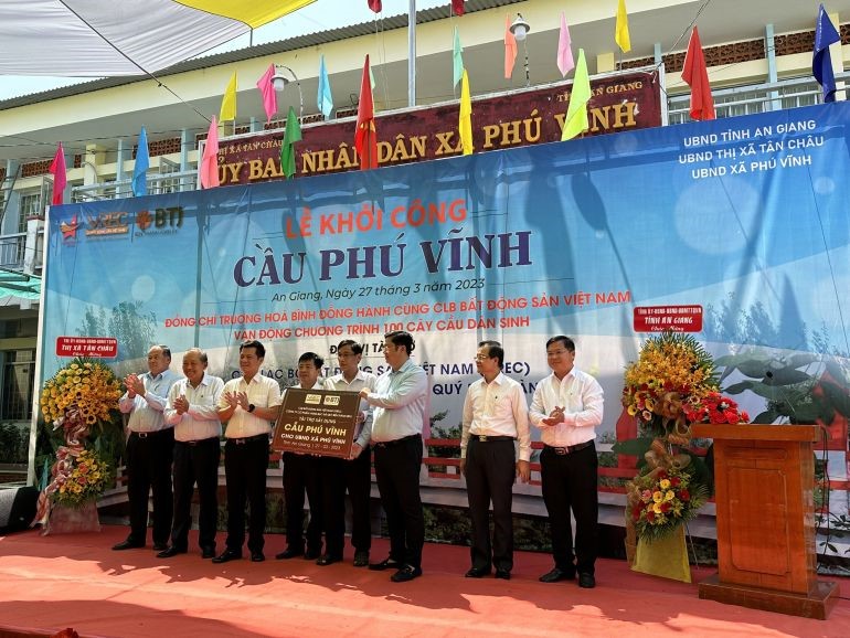VREC Chairman Nguyen Quoc Bao (3rd from the left) presented the symbolic board of Phu Vinh Bridge to the People's Committee of Phu Vinh Commune with the witness of Mr. Truong Hoa Binh - Former Permanent Deputy Prime Minister (2nd from left). Sang) with all leaders, entrepreneurs, and relatives in Phu Vinh commune, Tan Chau town, An Giang province.