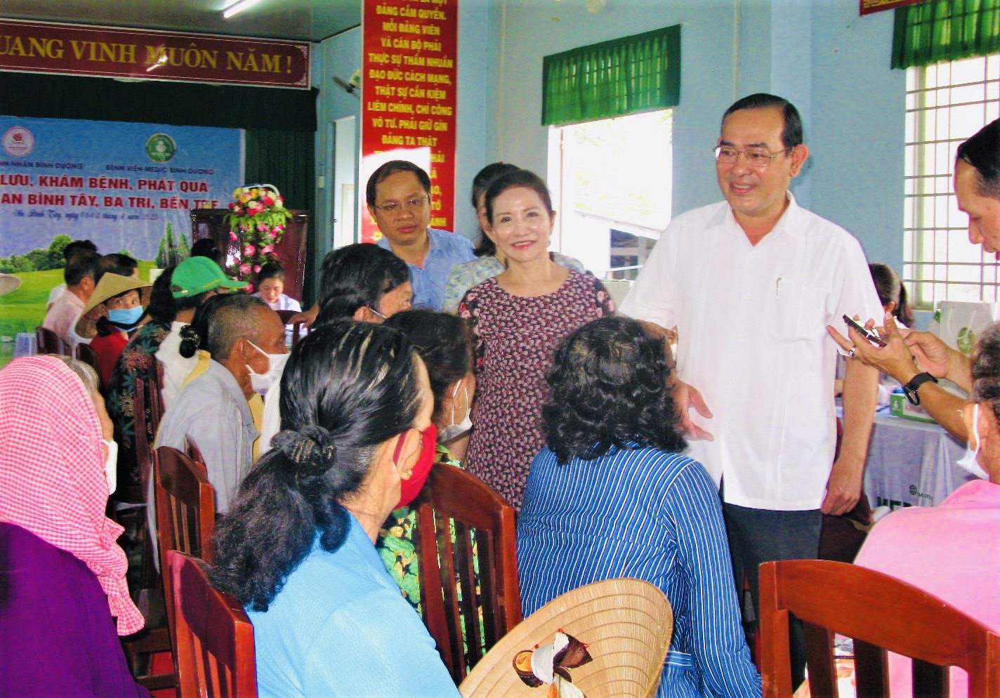 Trong ảnh là Đại diện lãnh đạo địa phương cùng Đoàn từ thiện ở Bình Dương thăm hỏi sức khỏe của người dân xã An Bình Tây, huyện Ba Tri