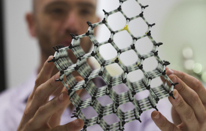 Nhân viên Element Six cầm mô hình cấu trúc phân tử của một viên kim cương. Ảnh: Bloomberg