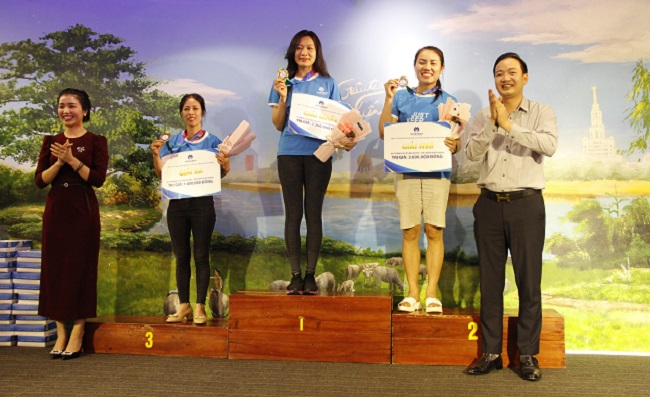Ông Nguyễn Tất Tùng (Bên phải) - CT HĐQT và bà Nguyễn Mai (Bên trái) cùng trao giải Nhất, Nhì, Ba hạng mục thi đấu chạy cá nhân Nữ.