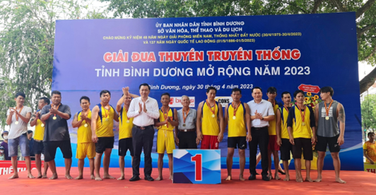 Ông Cao Văn Chóng -PGĐ Sở VHTTDL và ông Trần Bảo Lâm-PCT UBND TP Thủ Dầu Một trao thưởng cho đội Dầu Tiếng (đạt hạng nhất nội dung 500m)
