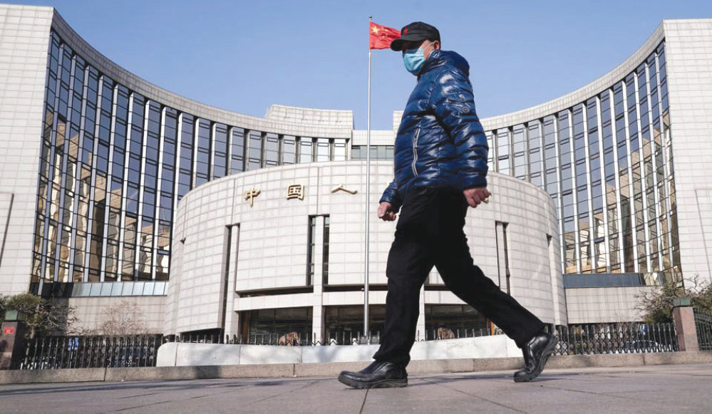 Một người đàn ông đi ngang qua trụ sở Ngân hàng Nhân dân Trung Quốc ở Bắc Kinh (Ảnh: Reuters)