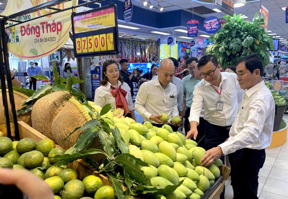 Ông Nguyễn Hữu Dũng (bìa phải), Giám đốc Sở Công thương tỉnh Đồng Tháp đang giới thiệu về xoài tại siêu thị.