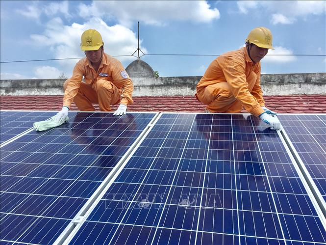Công nhân điện đang kiểm tra chất lượng pin năng lượng mặt trời lắp ở nhà dân tại huyện Châu Thành, tỉnh Tây Ninh. Ảnh: TTXVN