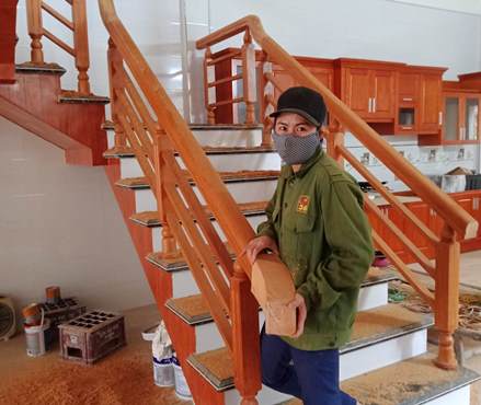 Chị Thu đang lắp ráp cầu thang bằng gỗ mỹ nghệ cho khách hàng