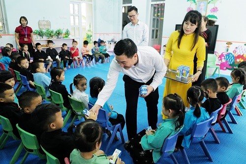 Students of Vo Ngai Kindergarten sit neatly, eagerly waiting for milk cartons.