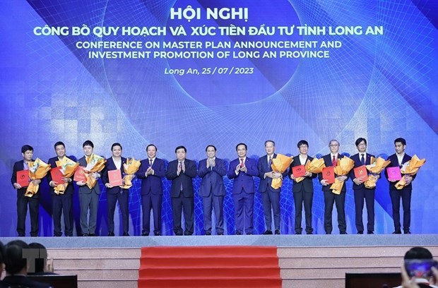 Prime Minister Pham Minh Chinh witnessed the awarding of investment registration certificates of Long An province to investors. (Photo: Duong Giang/VNA).