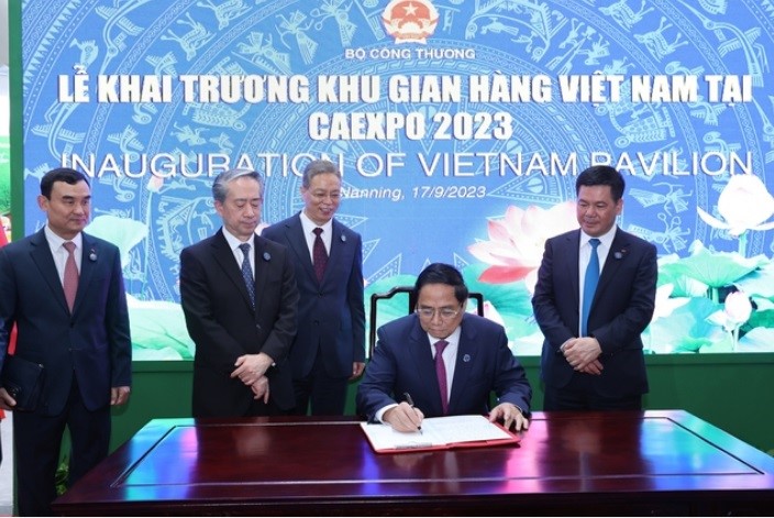 Prime Minister Pham Minh Chinh writes in the guestbook at the Vietnam Pavilion.