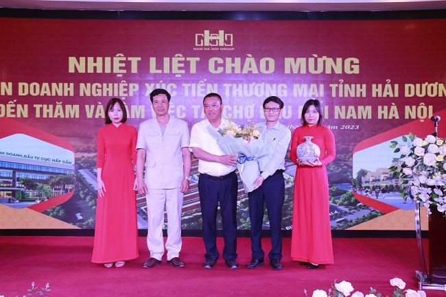 Ông Ngô Quang Hoàn - Chủ tịch Hội Mỹ nghệ và kim hoàn, đá quý - Hiệp hội Doanh nghiệp vừa và nhỏ tỉnh Hải Dương trao tặng hoa và qua cho lãnh đạo Chợ đầu mối Nam Hà Nội
