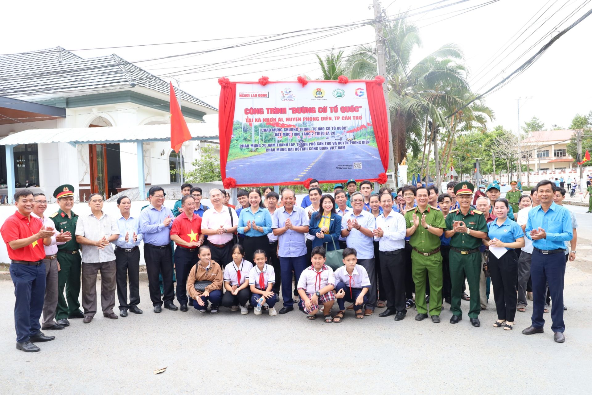 Các đại biểu và nhân dân chụp hình lưu niệm tại công trình “Đường cờ Tổ quốc” huyện Phong Điền.