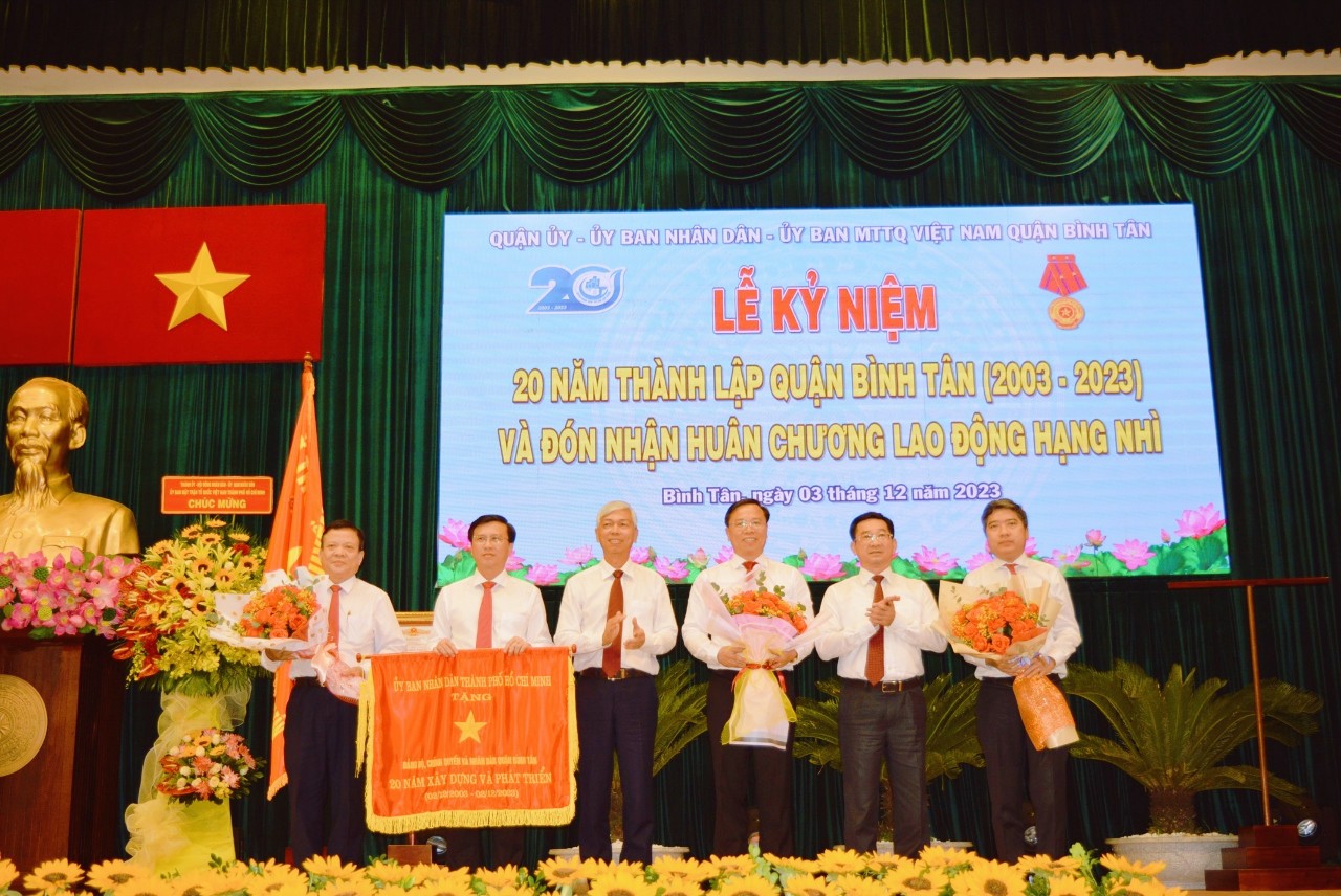 Chủ tịch UBND TPHCM tặng Cờ truyền thống đối với Đảng bộ, chính quyền và nhân dân quận Bình Tân. Ảnh  - Bích  Liên