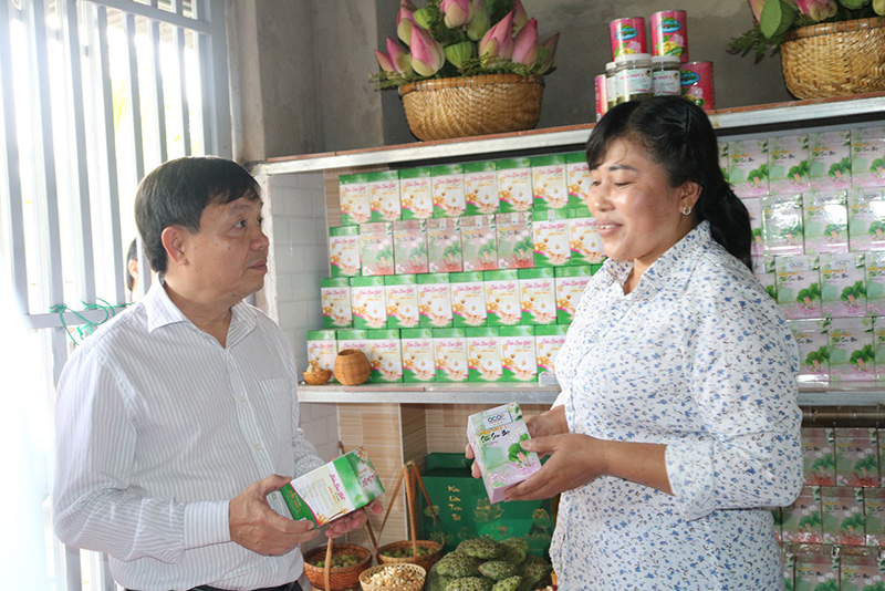 Đồng chí Phan Văn Thắng - Phó Bí thư Thường trực Tỉnh ủy, Chủ tịch Hội đồng nhân dân tỉnh (bên trái) tìm hiểu sản phẩm của Cơ sở sản xuất Sữa sen Diễm Thúy 2 (thị trấn Mỹ An, huyện Tháp Mười)