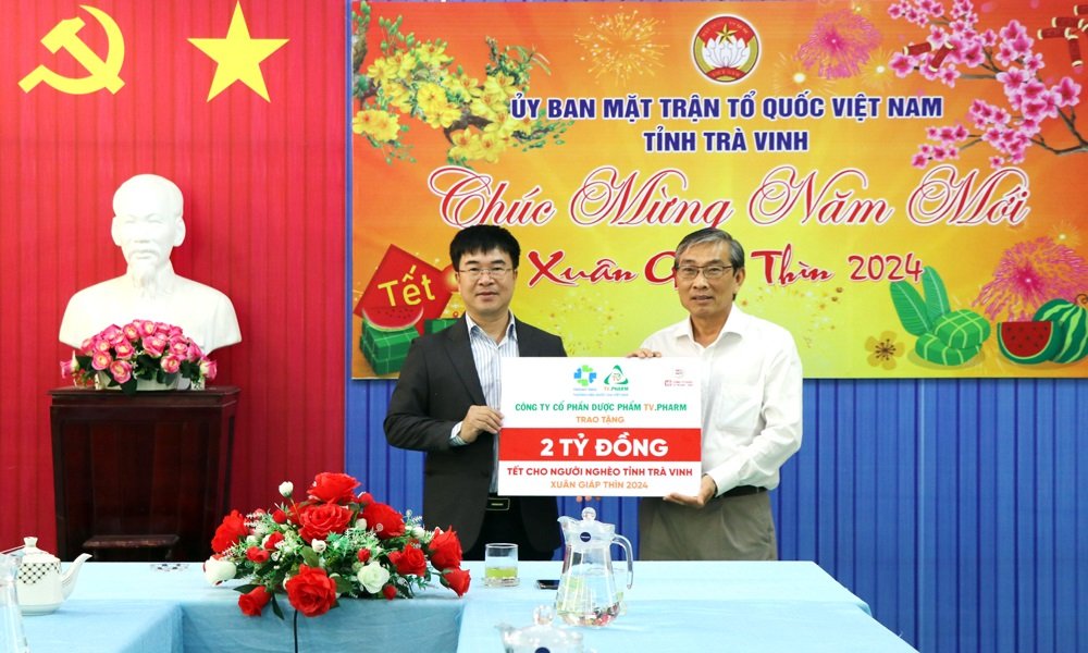 Ông Hà Ngọc Sơn, Tổng Giám đốc Công ty Cổ phần Dược phẩm TV.PHARM (bìa trái) trao bảng tượng trưng 02 tỷ đồng cho Ban Thường trực UBMTTQ Việt Nam tỉnh.