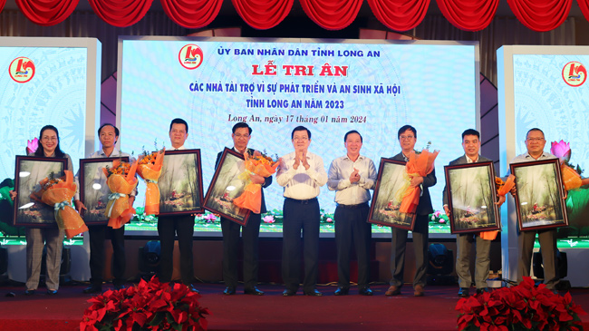 Former President Truong Tan Sang and Chairman of the Provincial People’s Committee - Nguyen Van Ut present flowers and gifts to honour sponsors