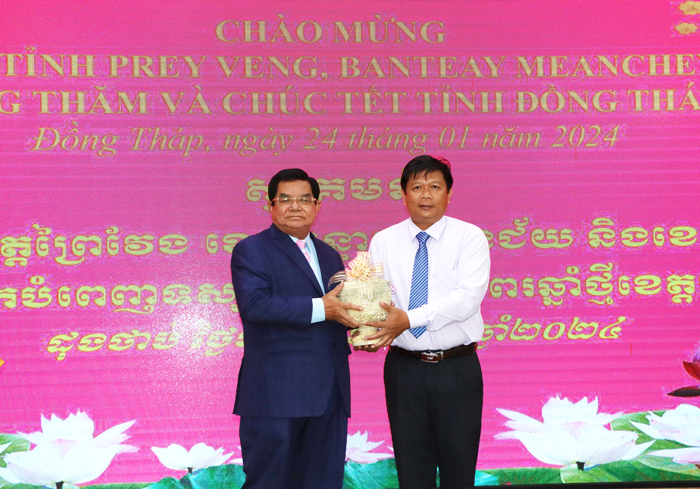Mr Vo Ngoc Thanh - Vice Chairman of the Vietnam Fatherland Front Committee of the province receives congratulatory gifts from Mr Mok Ra - Chairman of the Pur-sat Provincial Council