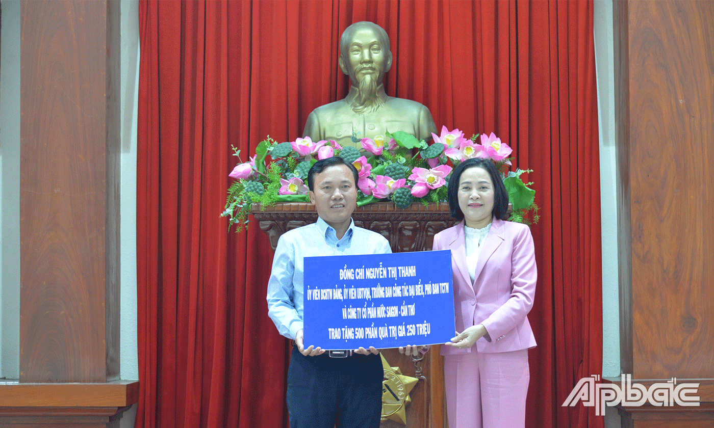 Đồng chí Nguyễn Thị Thanh trao Bảng tượng trưng tặng 500 phần quà.