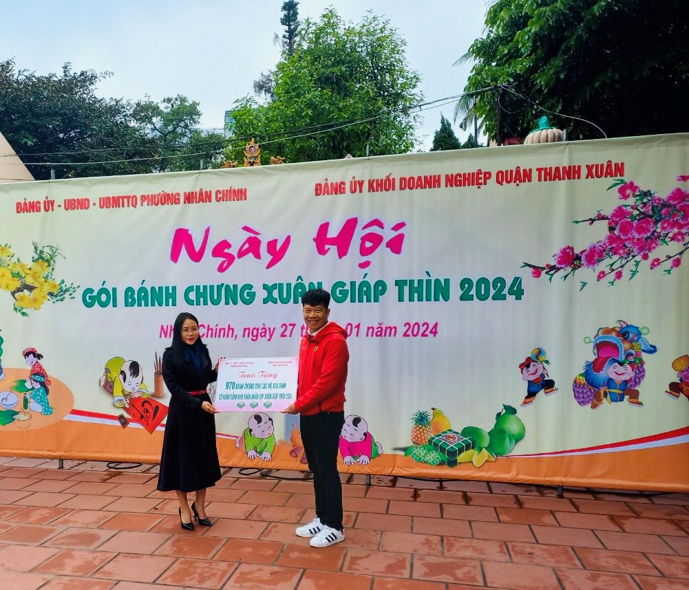 Đồng chí Nguyễn Văn Minh (người đứng bên phải) - QUV, Bí thư Đảng ủy Khối và đồng chí Nguyễn Thị Hà Phương - PCT UBND phường Nhân Chính trao tặng 970 bánh chưng cho các hộ gia đình khó khăn trên địa bàn phường