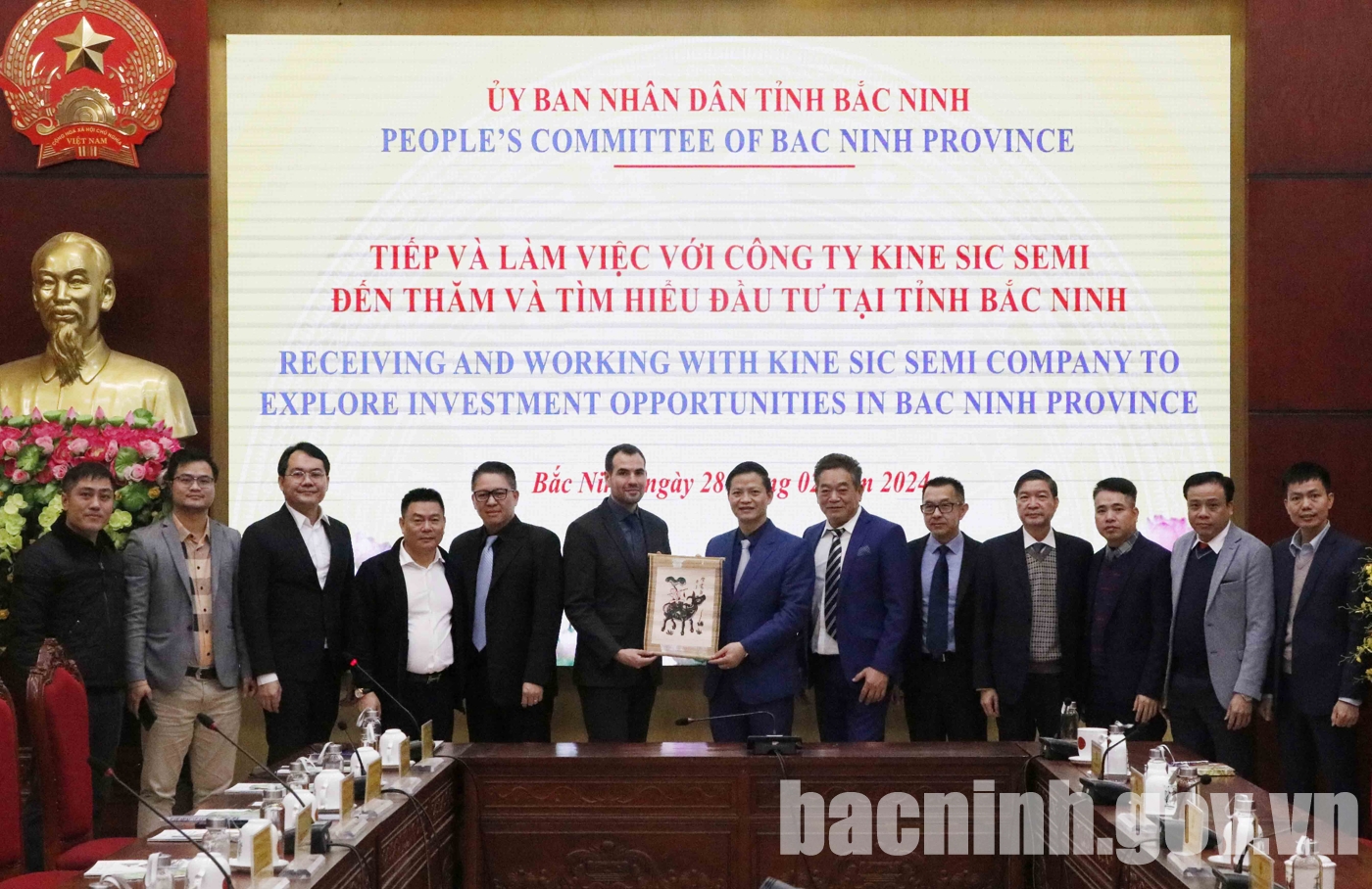 Phó Chủ tịch Thường trực UBND tỉnh Vương Quốc Tuấn (thứ 7 từ phải qua) tặng tranh dân gian Đông Hồ cho Công ty Kine SIC Semi.