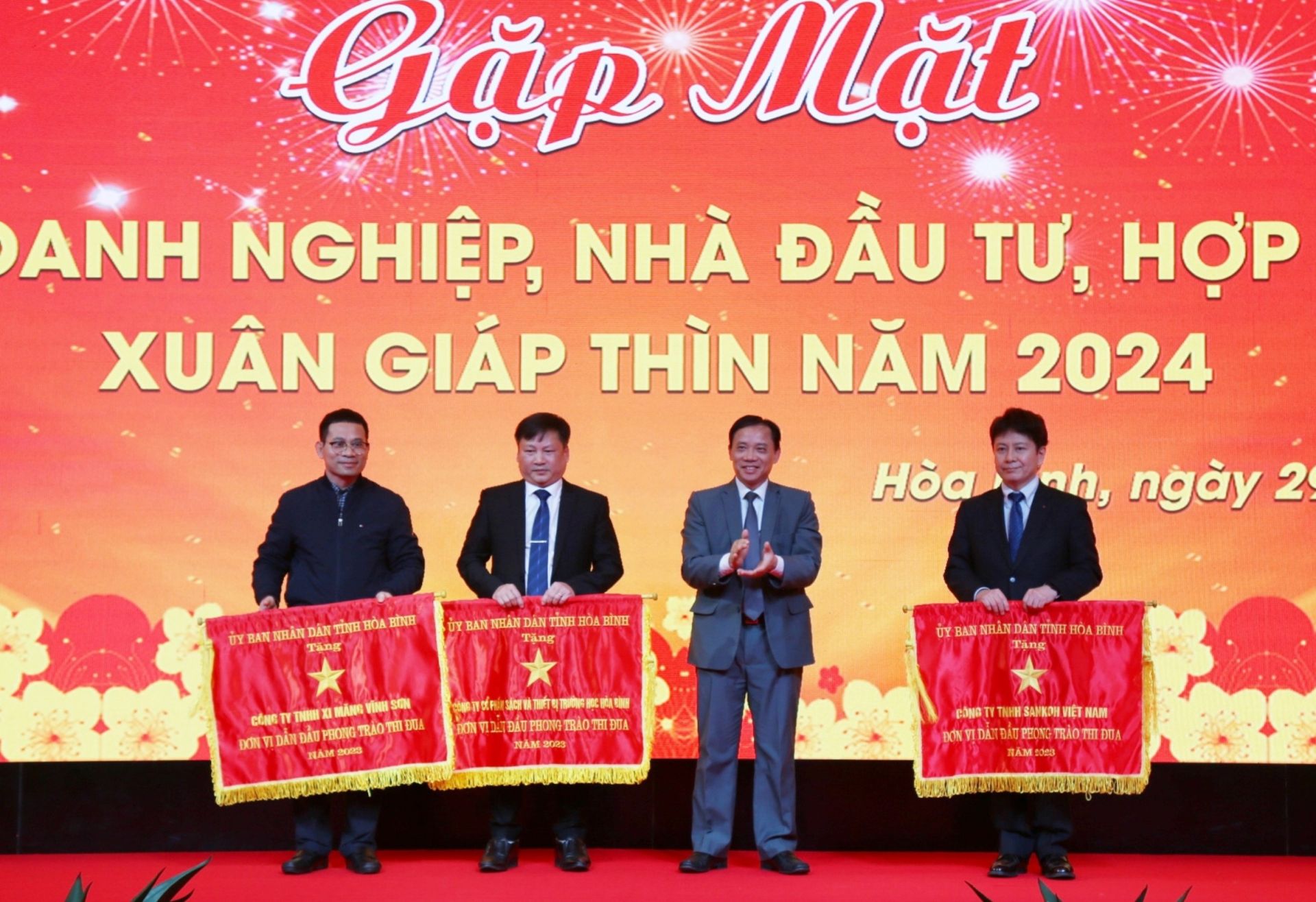 Chairman of the Hoa Binh Provincial People’s Committee Bui Van Khanh presents the Flag of the leading unit in the patriotic emulation movement in 2023 to 3 businesses