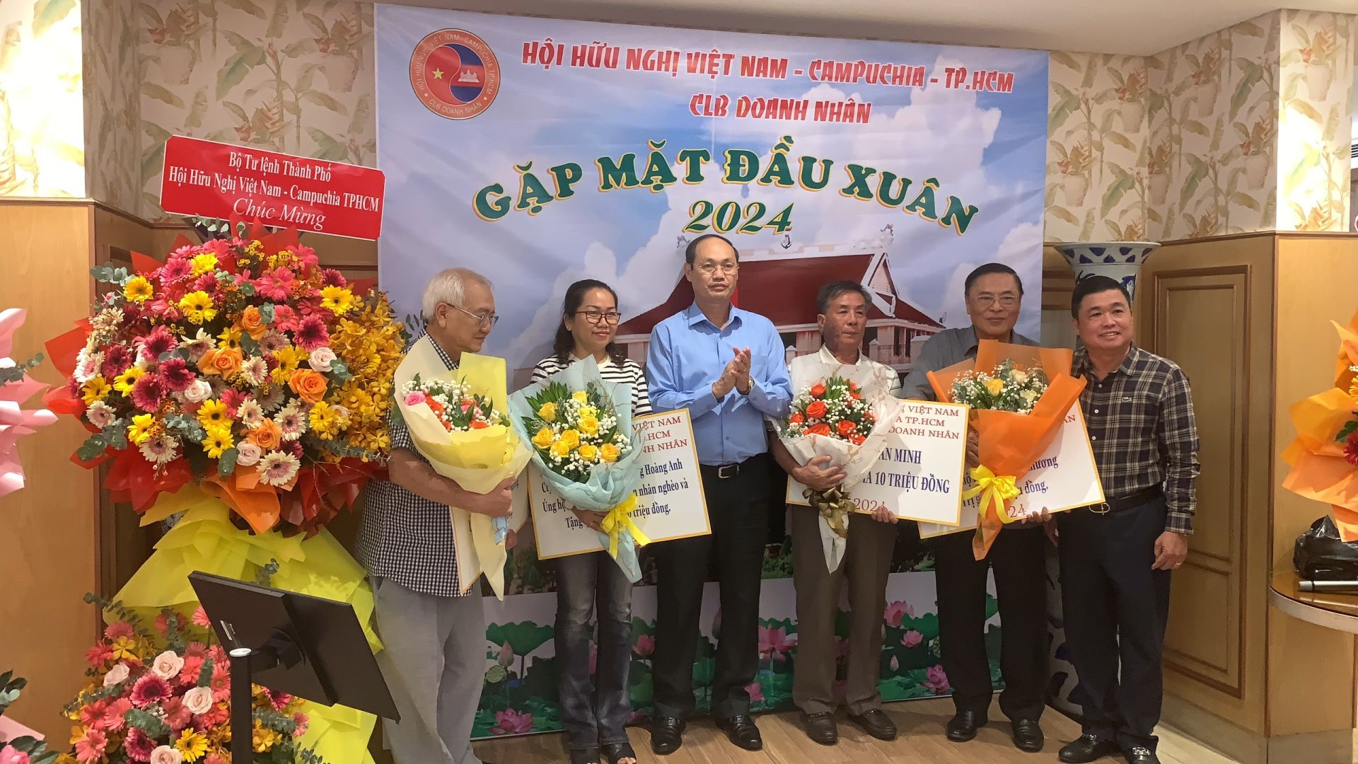 Lieutenant General Nguyen Van Nam presents flowers to businesses that have made significant contributions to the social and charitable activities of the Ho Chi Minh City Vietnam - Cambodia Friendship Association