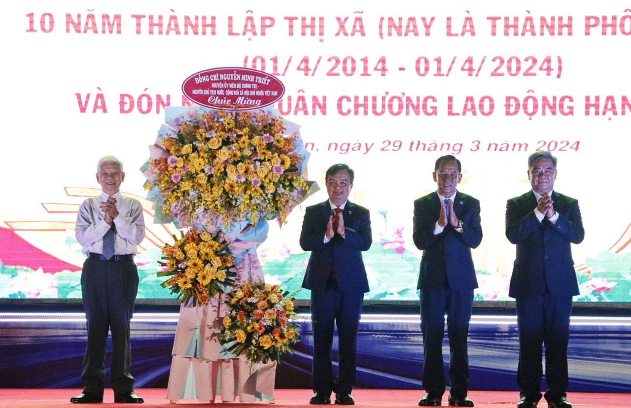 Nguyên Ủy viên Bộ Chính trị, nguyên Chủ tịch nước Nguyễn Minh Triết tặng hoa chúc mừng TP Tân Uyên