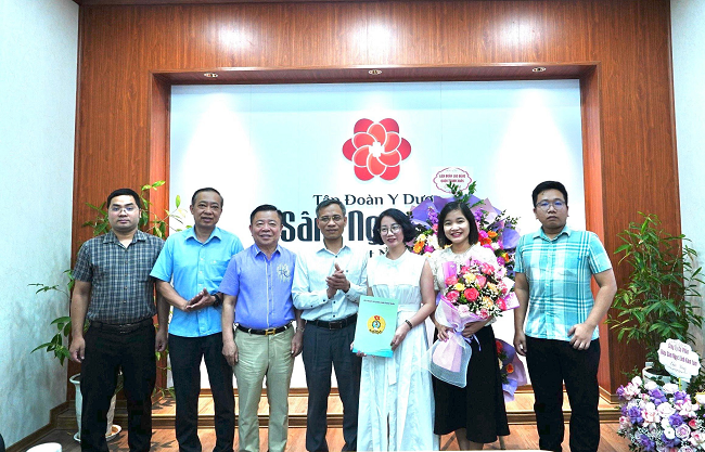 Đồng chí Cao Đắc Tiến – Quận ủy viên, Chủ tịch Liên đoàn lao động Quận Thanh Xuân (người đứng giữa) trao Quyết định thành lập Công đoàn Công ty cổ phần Tập đoàn y dược Sâm Ngọc Linh Việt Nam.