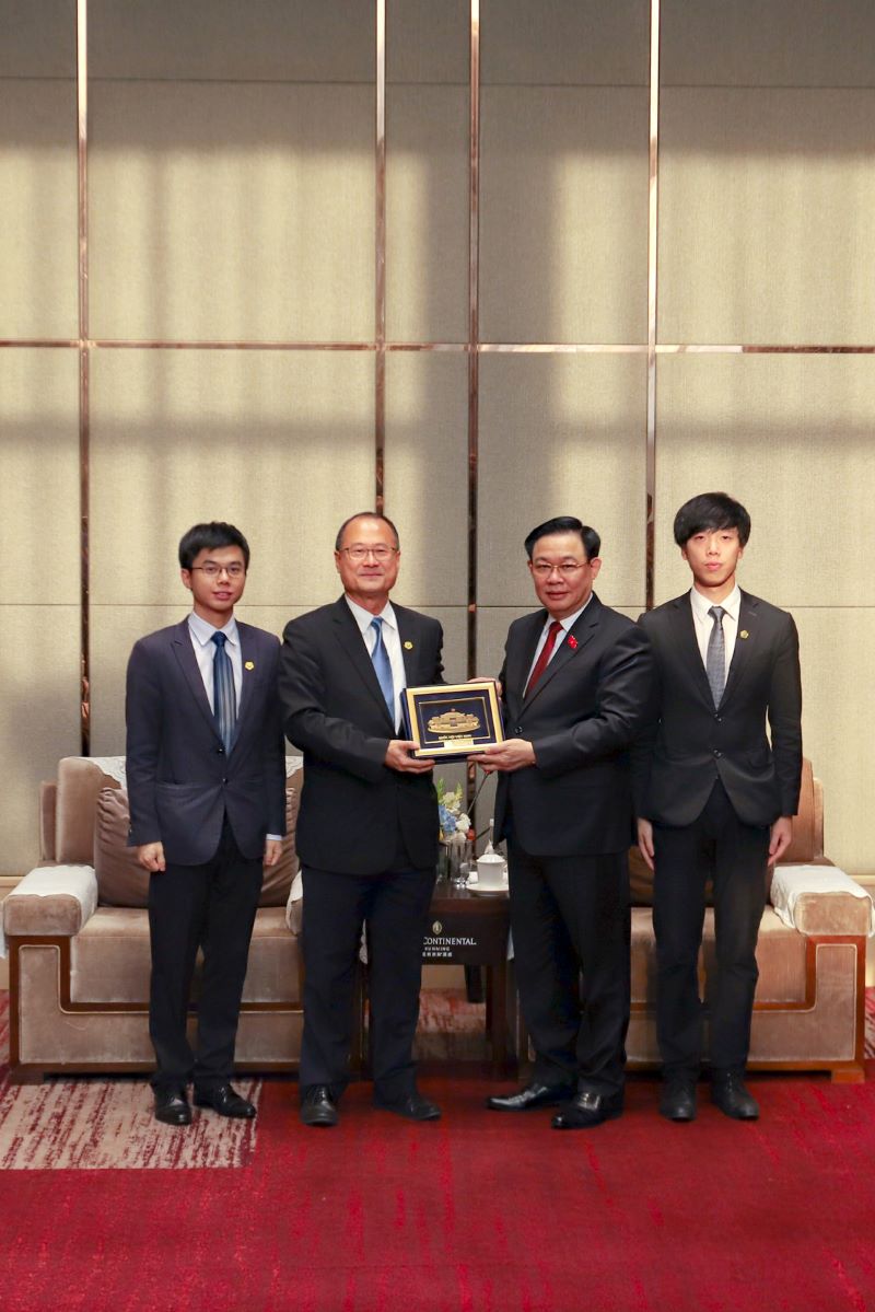 Dr Jonathan Choi with his two sons: Mr Jesse Choi (far right), General Director of Sunwah Group in ASEAN and Vietnam, and Mr Jason Choi (far left), General Director of Sunwah Group in the Guangdong-Hong Kong-Macau Greater Bay Area, receiving a souvenir from National Assembly Chairman Vuong Dinh Hue
