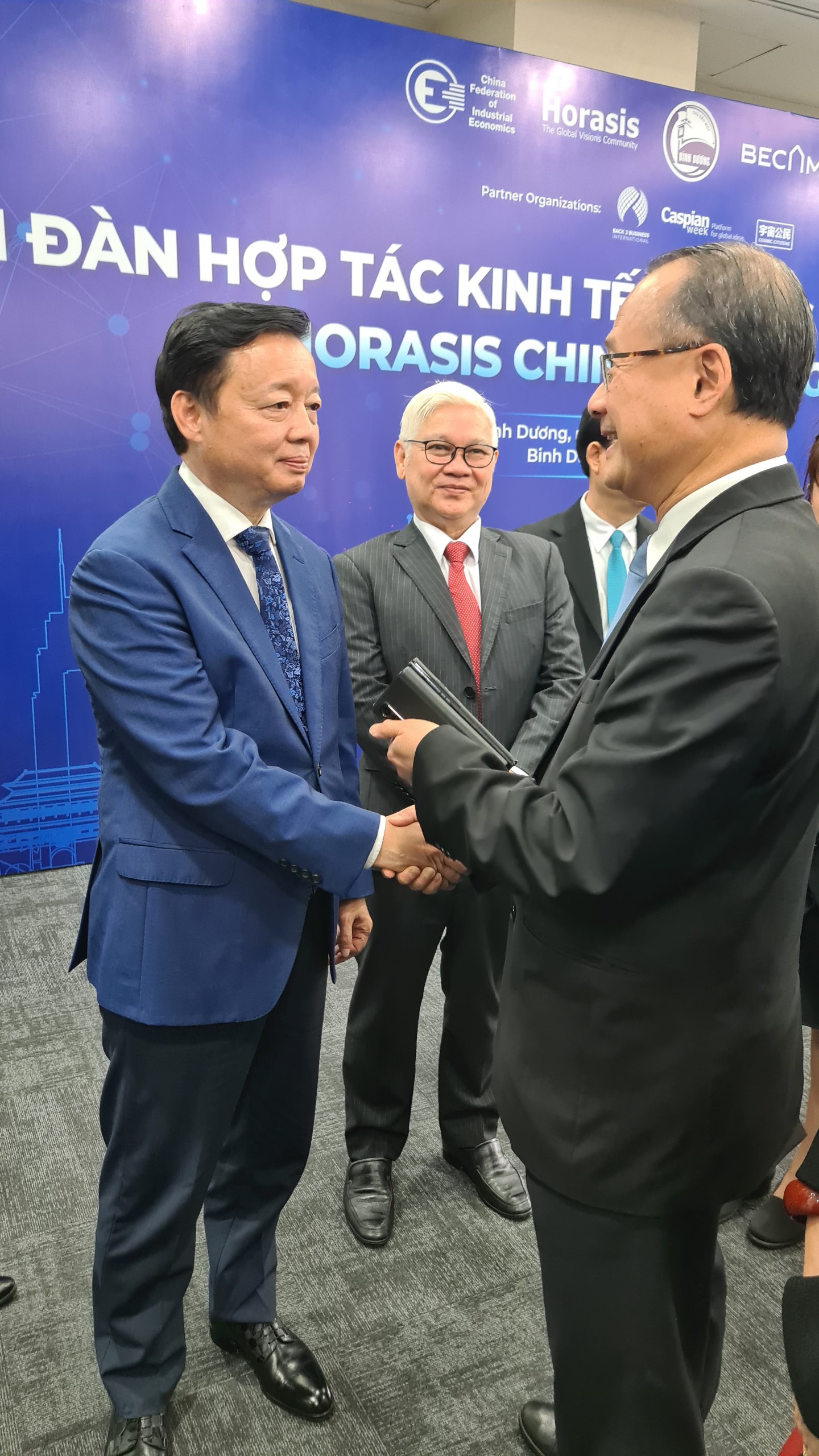 Deputy Prime Minister Mr Tran Hong Ha (left) talked with Dr Jonathan Choi and Binh Duong Secretary of the Provincial Party Committee Mr Nguyen Van Loi (middle)