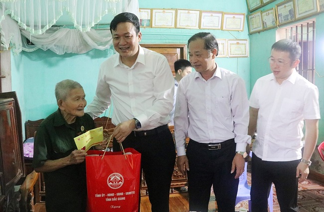 Phó Chủ tịch UBND tỉnh Lê Ô Pích và đại diện lãnh đạo Ủy ban MTTQ tỉnh và huyện Lục Ngạn thăm, tặng quà CCB Vi Văn Bình ở thôn Thanh Tân, xã Trù Hựu.