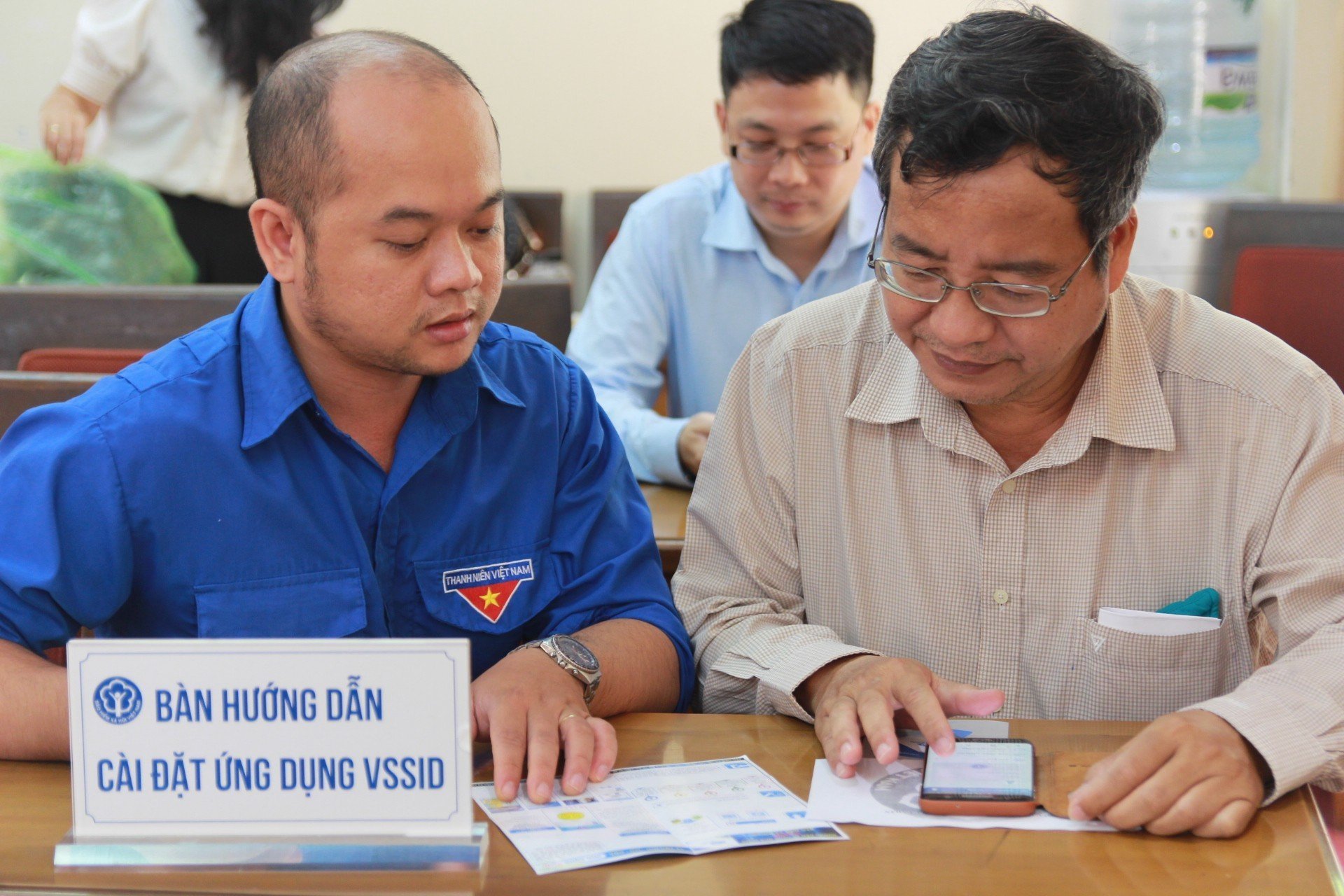 Viên chức BHXH TP. Hồ Chí Minh hướng dẫn người dân cài đặt ứng dụng VSSID
