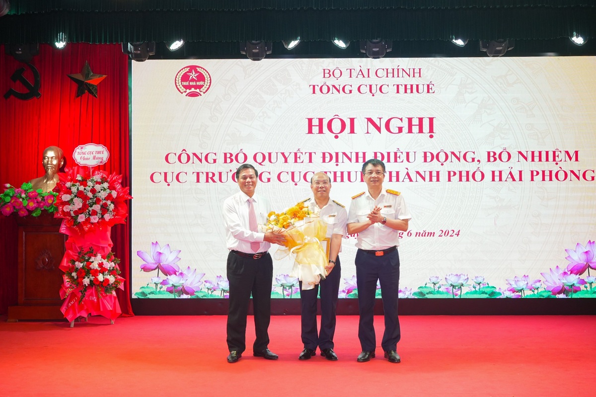 Chủ tịch UBND thành phố Nguyễn Văn Tùng và Tổng Cục trưởng Tổng cục Thuế Mai Xuân Thành tặng hoa chúc mừng Tân Cục trưởng Cục Thuế thành phố Nguyễn Tiến Trường