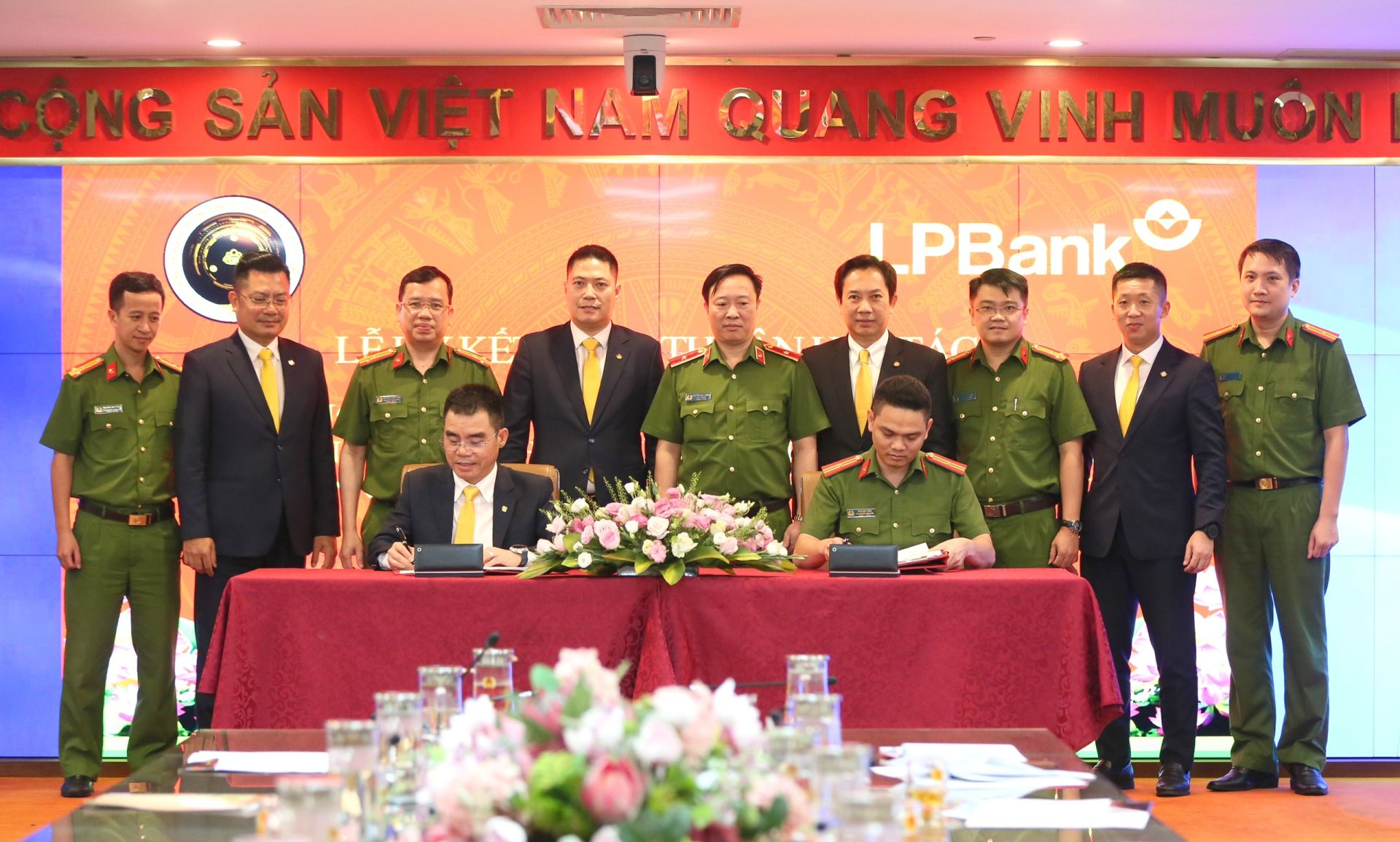 Giám đốc Trung tâm RAR  - Thiếu tá Trần Duy Hiển (bên phải) và Phó Chủ tịch HĐQT kiêm Tổng giám đốc LPBank Hồ Nam Tiến (bên trái) cùng lãnh đạo hai Bên thực hiện ký kết thoả thuận hợp tác