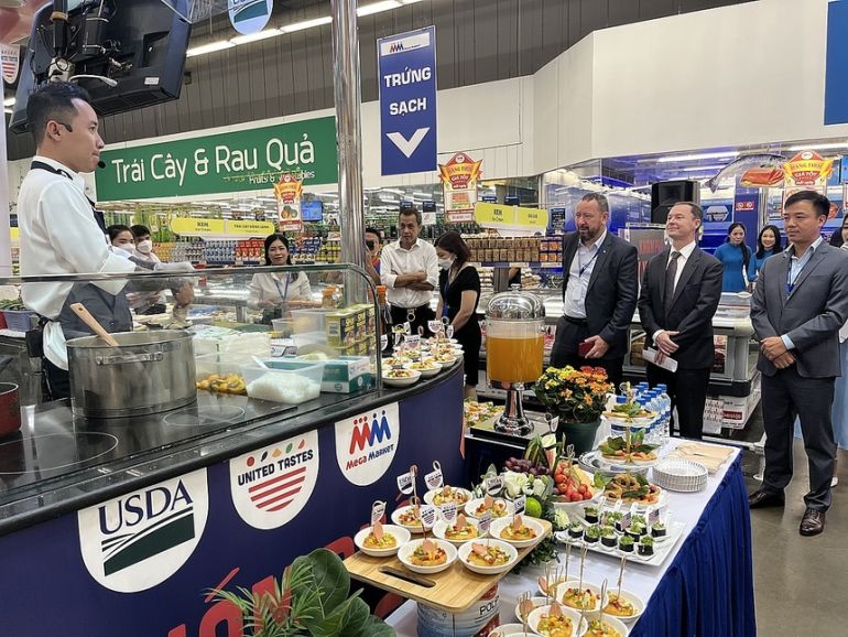 Mr. Ralph Bean, Agricultural Attaché at the U.S. Embassy in Hanoi (second from the left), is watching a Vietnamese chef demonstrate cooking Vietnamese dishes using ingredients from the United States