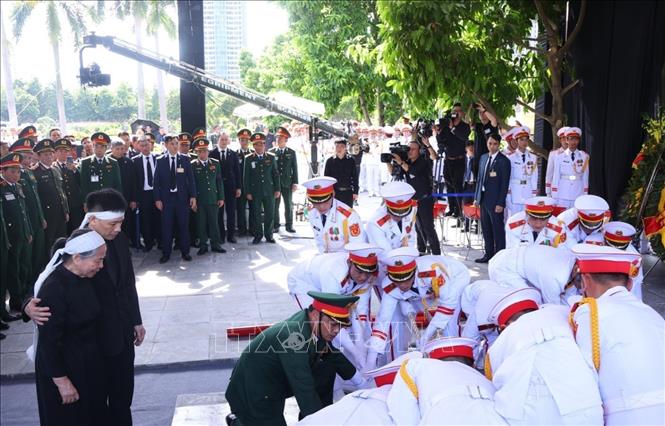 Gia đình cùng các đại biểu chứng kiến Đội nghi lễ tiến hành hạ huyệt linh cữu Tổng Bí thư Nguyễn Phú Trọng. Ảnh: TTXVN