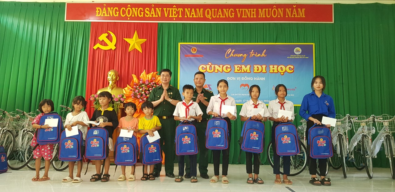 Trung tá Nguyễn Hoài Phong - Phó Bí thư Chi bộ, Đồn trưởng Đồn Biên phòng Lò Gò và CCB Nguyễn Công Trung, Chủ tịch CLB Trái tim người lính miền Tây trao quà cho học sinh nghèo.