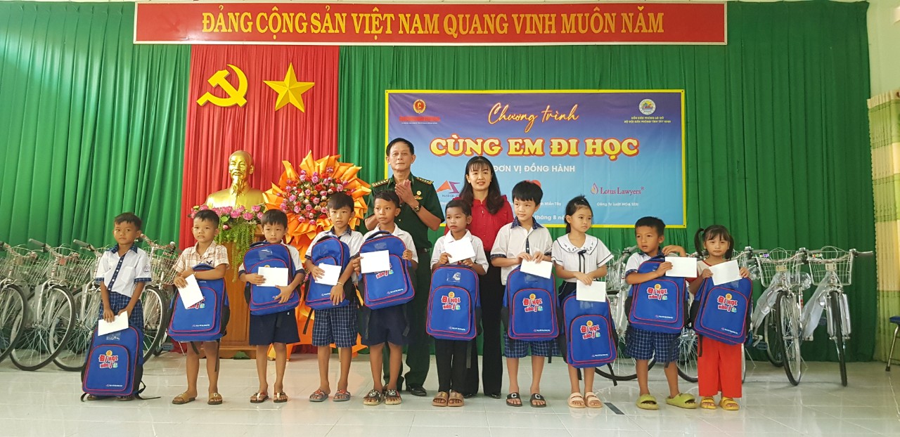 Đại diện Báo CCBVN và lãnh đạo UBND xã Hòa Hiệp trao quà cho học sinh nghèo, đồng bào Khơ - me